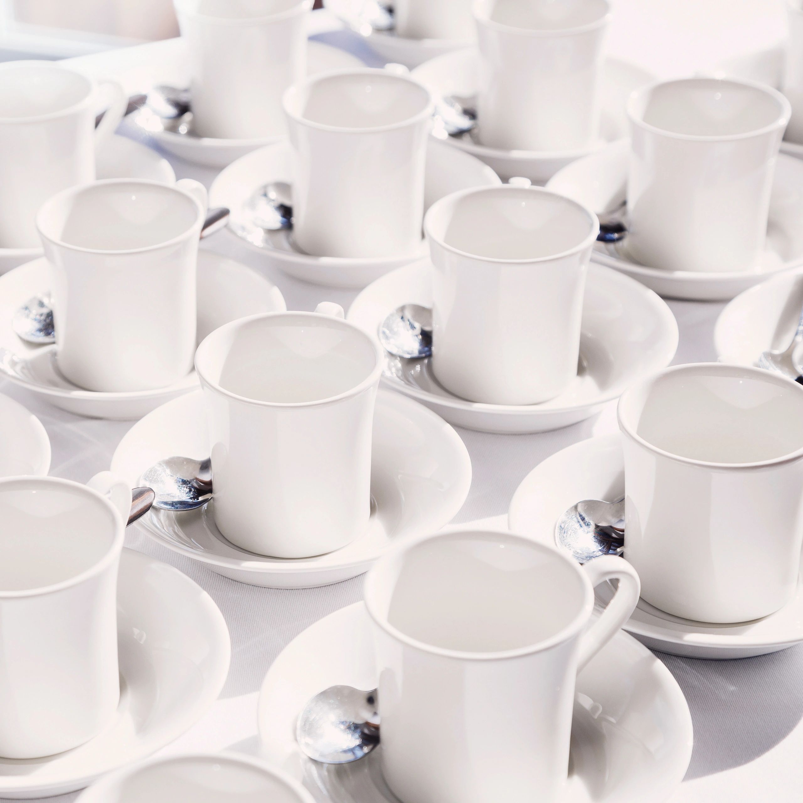 White coffee cups arranged on a table in a polished café setting